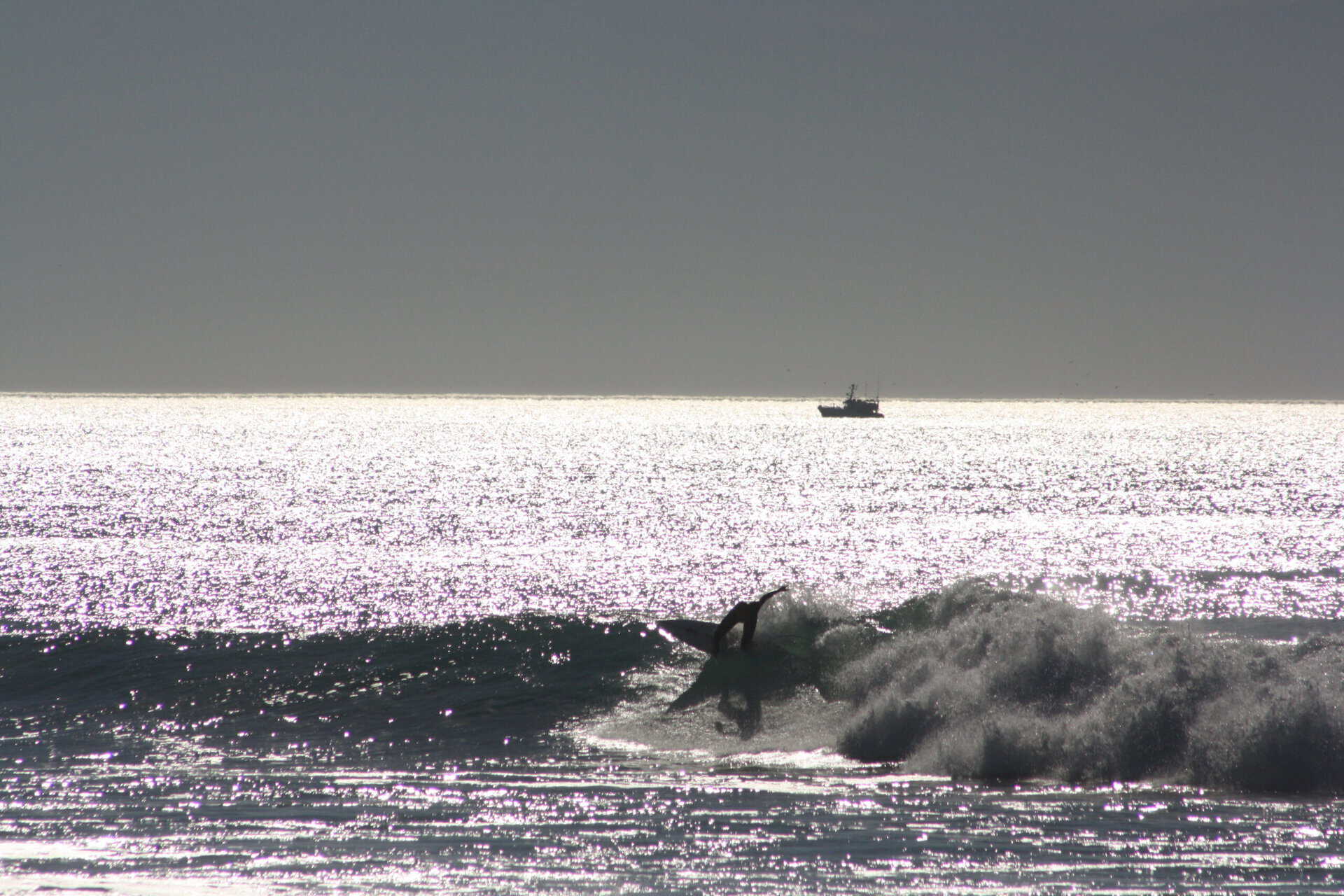 Surfeur en action en contre-jour sur une vague du Truc Vert, Cap-Ferret